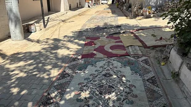 İzmir’de tozdan bunalan mahalleli onarılmayan yollara halı serdi